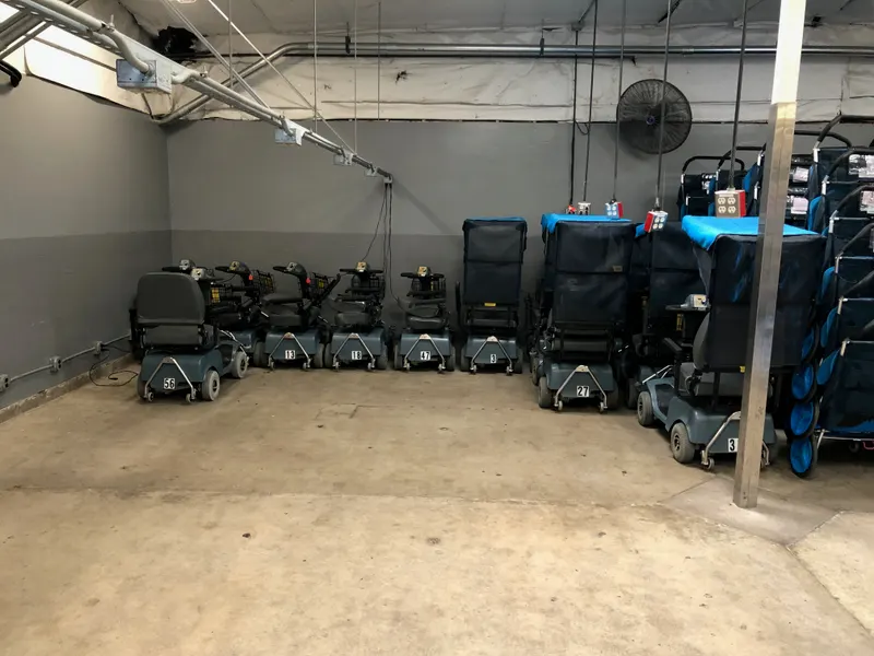 Mobility scooters and strollers staged in an equipment room.