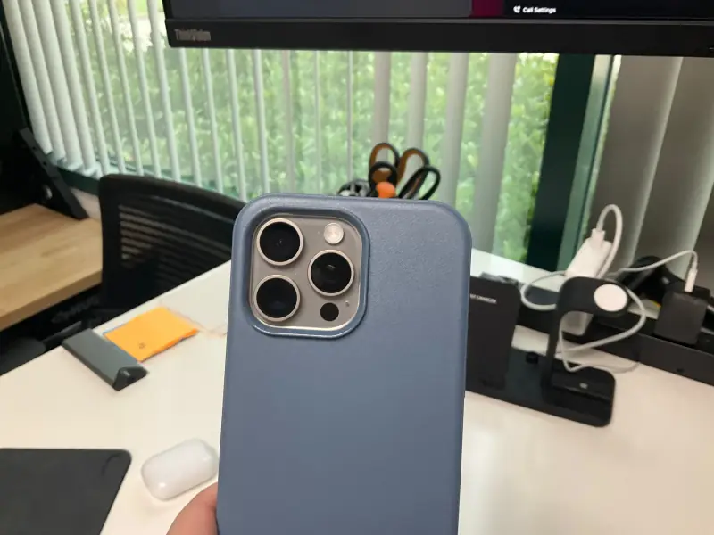 iPhone 15 Pro Max in a blue case.