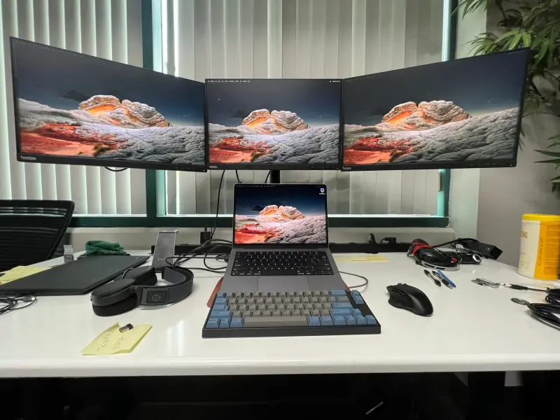 Laptop and three-monitor setup.